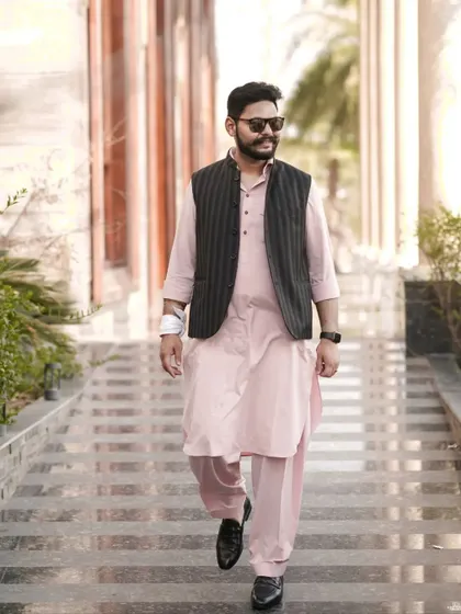 The groom looking cool and relaxed in his Haldi outfit, walking पुलिस a modern pathani suit and a Nehru jacket.