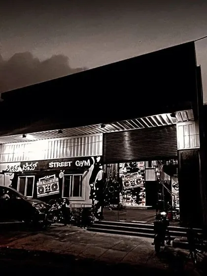The exterior view of 'Street Gym' at night, where our graffiti art is visible from the outside, creating a strong street presence for the brand.