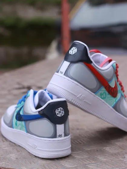 A pair of Air Force 1s inspired by board games: Monopoly and Scotland Yard. Each shoe has a different theme, with custom red and blue swooshes.