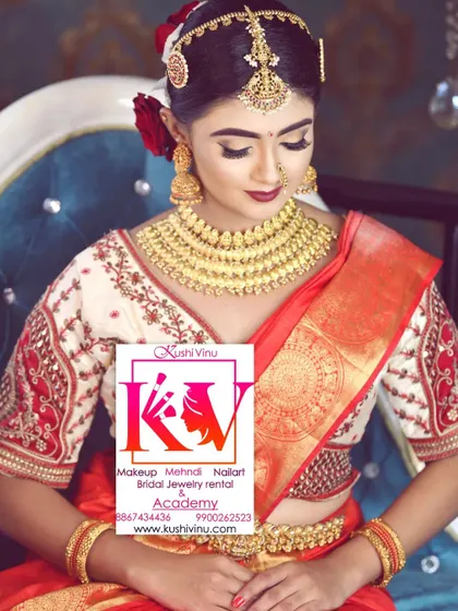 A full view of a traditional bride in a red and cream saree. I provided the complete look, including the HD makeup, the hair styled with fresh flowers, and the perfectly draped saree.