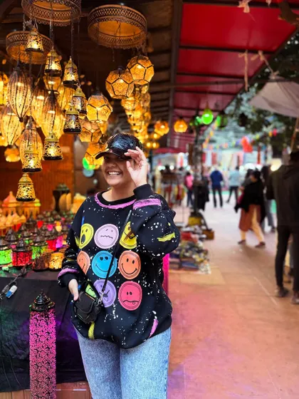 Having fun at Dilli Haat. I love the vibrant atmosphere, and my colorful smiley-face sweatshirt perfectly matched the mood.