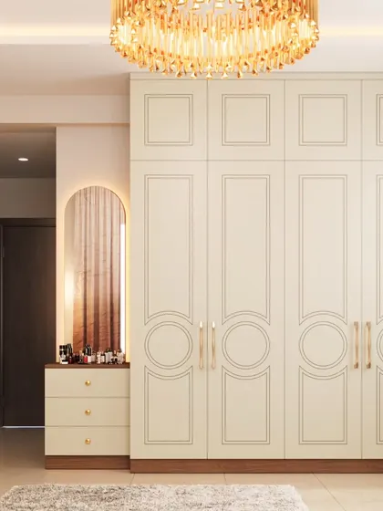 A classic and elegant floor-to-ceiling wardrobe in a soft cream finish. The paneled doors with subtle circular details and brass handles add a touch of timeless sophistication to the bedroom.