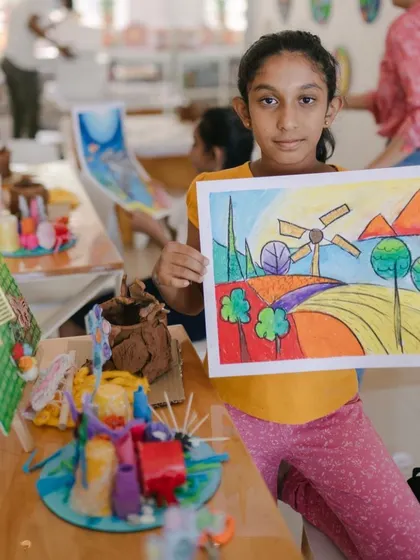 A proud moment captured at our camp's art show. This young lady created a beautiful and vibrant landscape using oil pastels, showcasing her new skills in blending and composition.