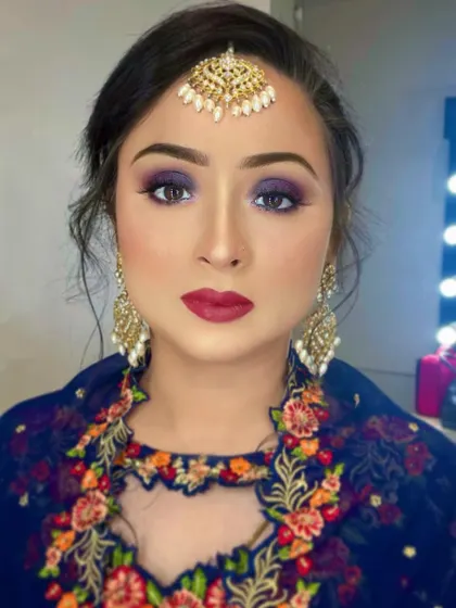 A stunning blue smokey eye paired with a bold red lip. This is a classic combination for a glamorous evening event, perfect for Eid or any festive celebration.
