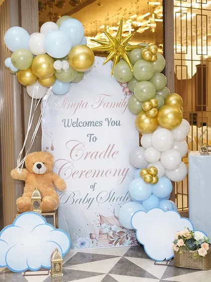 The personalized welcome sign for the cradle ceremony, decorated with balloons and cloud cutouts to match the celestial theme.