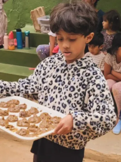A child proudly presents a tray of "mersu," a recreation of an ancient Mesopotamian recipe found on a clay tablet. This project was a spontaneous fusion of history, geometry, and cooking.