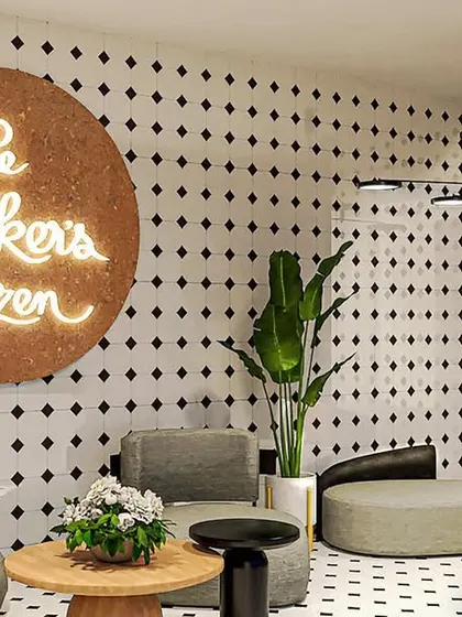 The reception area for The Baker's Dozen office, featuring their logo against a cork background and a playful tiled wall. This space is designed to be welcoming and reflective of the brand's fun personality.