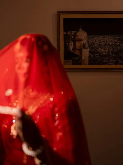 A mysterious and beautiful shot of the bride behind her red veil. This artistic photo focuses on the color and texture, creating a sense of anticipation and romance.