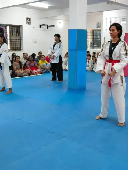 An instructor observes students as they practice their forms.