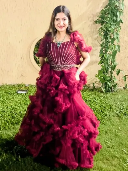 Our client looks absolutely captivating in this beetroot maroon ruffle gown. The dense ruffles on the skirt create incredible texture and volume.