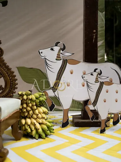 A close-up of the charming props used in the 'Banana Grove' wedding. These illustrated cutouts of a cow and calf add a unique and culturally significant touch to the overall decor.