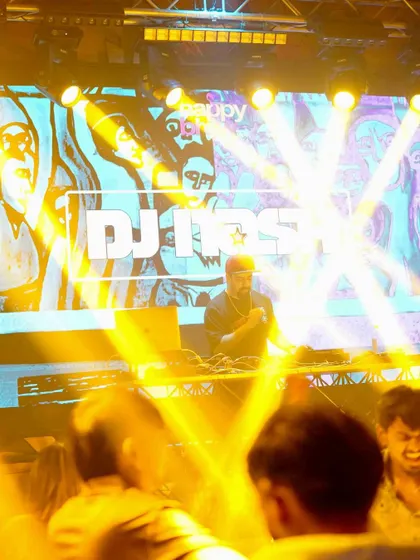 A shot from the crowd, looking up at me on the brightly lit stage at Happy Brew.