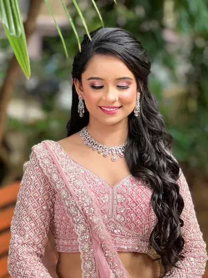 For the modern bride who loves a soft, romantic glow. This delicate diamond necklace and earring set is perfect for an engagement or reception. It provides that touch of sparkle without overpowering the intricate details of the pink lehenga.