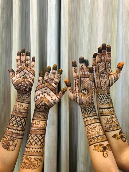 A fun shot of two clients showing off their matching elephant-themed mehendi designs.