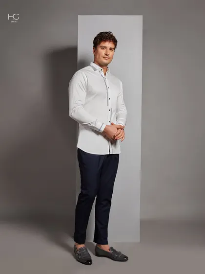 This white shirt with subtle trim is a versatile staple. Here it is styled for a smart, confident look suitable for any occasion, from the office to an evening out.