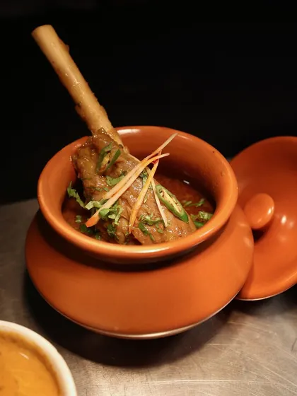 A rich lamb shank curry, slow-cooked and served in a traditional earthenware pot. This dish represents our expertise in classic, flavourful Indian cuisine.