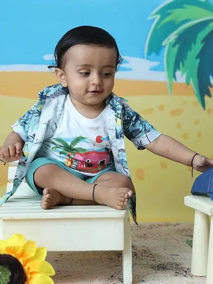 A playful moment as the toddler interacts with the props during the beach-themed shoot.