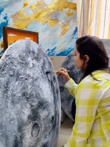 Adding the final details and shadows to a textured moon piece. This close up shows the brushwork that goes into creating the realistic, cratered surface of our moon art.