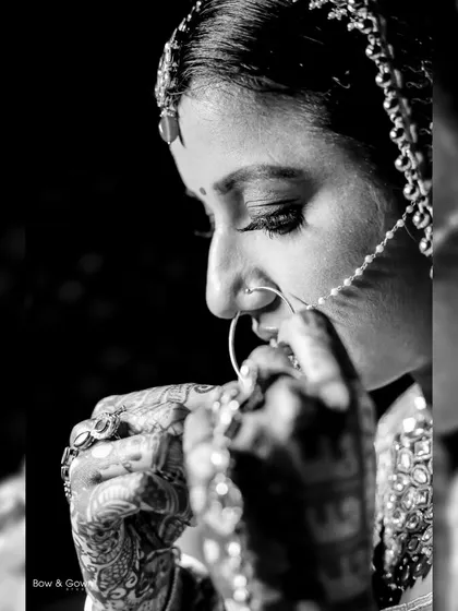 A classic black and white bridal portrait. This close-up shot of the bride adjusting her nose ring is intimate, detailed, and timeless.