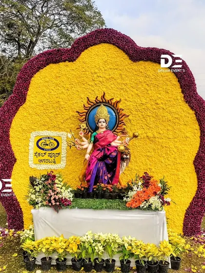 This installation features a statue of a goddess set against a massive, sun-like backdrop made of yellow and purple flowers. I designed this piece to be a vibrant and respectful tribute, blending spiritual iconography with natural beauty for the flower show.