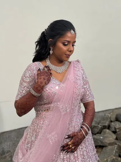 A beautiful outdoor shot of Surya. Her pink lehenga and shimmery makeup look stunning in the natural light.