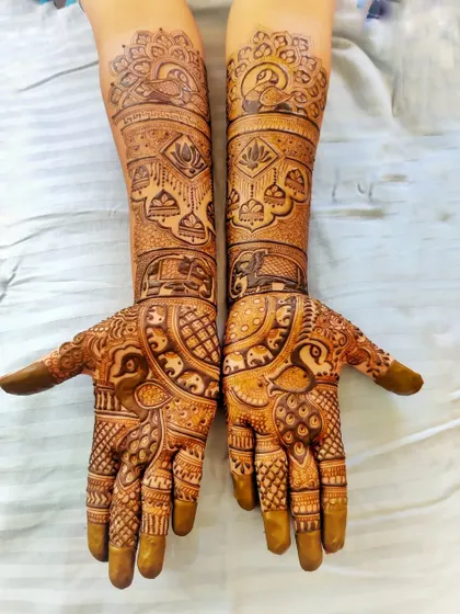 This engagement mehndi is filled with classic royal motifs like peacocks and elephants. It's a full, heavy design perfect for a bride who loves traditional art.
