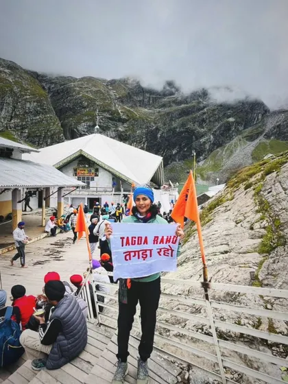 A member of the Tagda Tribe proudly displays our flag at a high-altitude pilgrimage site. This shows that the strength and spirit built in our dugouts travel with our members, supporting them on their personal journeys, wherever they may lead.