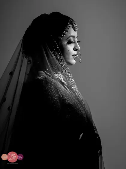 A dramatic black and white portrait of the bride, Rachita, her profile highlighted against the dark background.