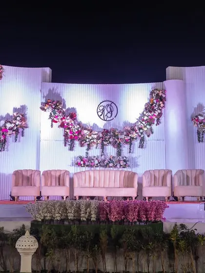 A grand reception stage with curved panels and cascading floral arrangements, creating a sophisticated and modern look for a celebration at the 711 Club.