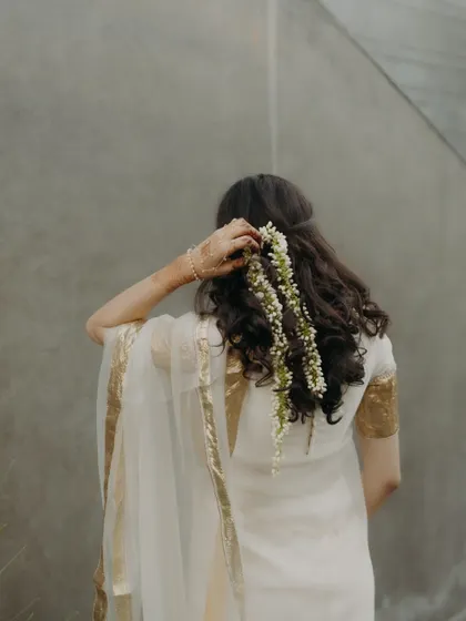 A back view of the bride's Haldi look, showcasing her beautiful gajra hairstyle.