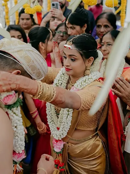 The bride places the garland on the groom, a key moment in the Jaimala ceremony. The expressions of the family around them add to the story of the day.