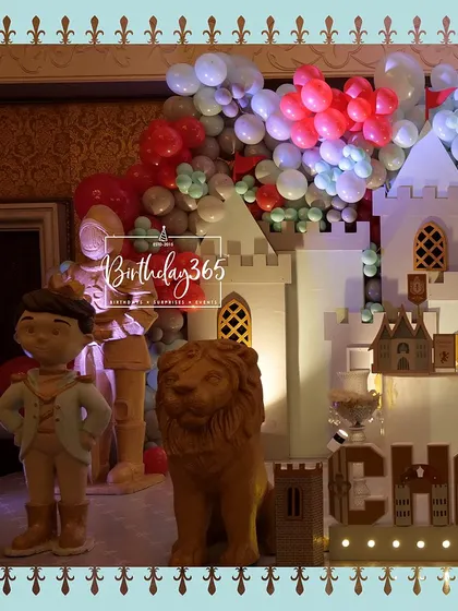 A close-up of the castle stage, showing the prince cutout and a golden lion statue.