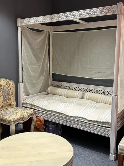 A full view of the ornate poster daybed, perfect for a lounge or a luxurious guest room. The design showcases our ability to create unique, handcrafted furniture pieces.