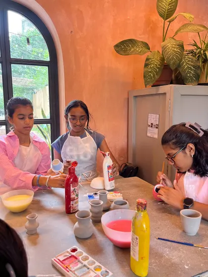 After the building comes the painting. These girls are adding vibrant colors to the small vases they created using hand-building methods.
