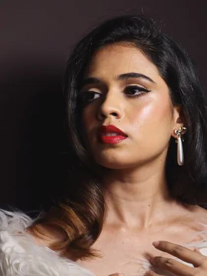 This profile view highlights the sharp winged liner and the carefully sculpted red lip, hallmarks of mid-century glamour.