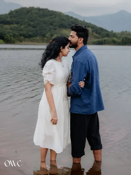 A tender forehead kiss by the water, this pre-wedding photo is the epitome of romance and tranquility.