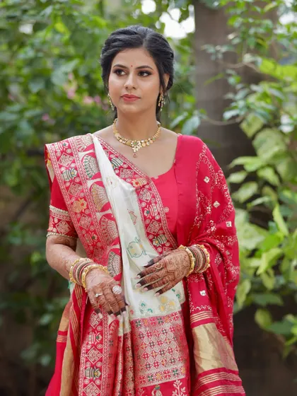 A classic portrait for her morning puja. The makeup is soft and traditional, paired with a beautiful red and white saree.
