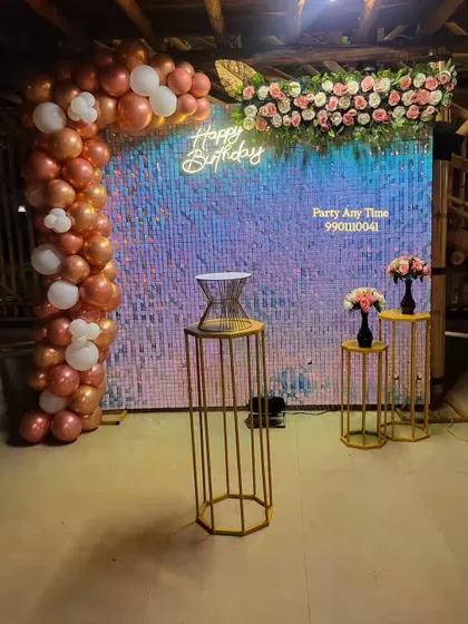 My shimmer sequin walls are available for rent and make a great photo backdrop. Here, I've paired an iridescent shimmer wall with a rose gold and white balloon arch, a floral arrangement, and a neon sign for a surprise birthday at a resort in Kanakapura.