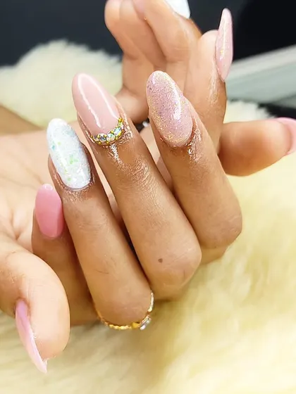 A soft and pretty set combining pink gel polish, glitter accent nails, and a delicate rhinestone cuticle design.