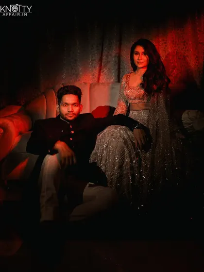 A moody, artistic portrait of the couple under dramatic red lighting. We love to experiment with color and light to create unique and memorable shots.