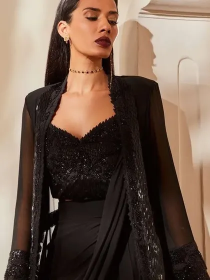 A black draped-saree look with an embroidered jacket is incredibly chic. I can design a similar Indo-Western outfit for a cocktail party or reception.