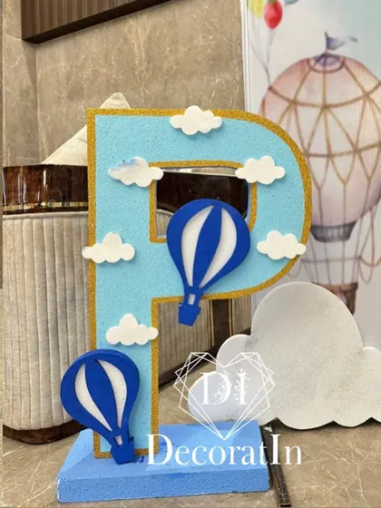A custom-made letter 'P' decorated with felt hot air balloons and clouds for a personalized touch.