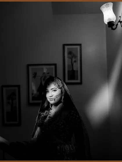 A stunning black and white portrait of the Nikah bride. The dramatic lighting highlights her beautiful features and traditional jewelry.