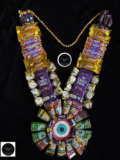 This ultimate chocolate garland is a dream for any sweet tooth this Holi. It features a wide assortment of chocolates like Dairy Milk, 5 Star, and Gems, centered around a beautiful evil eye design.