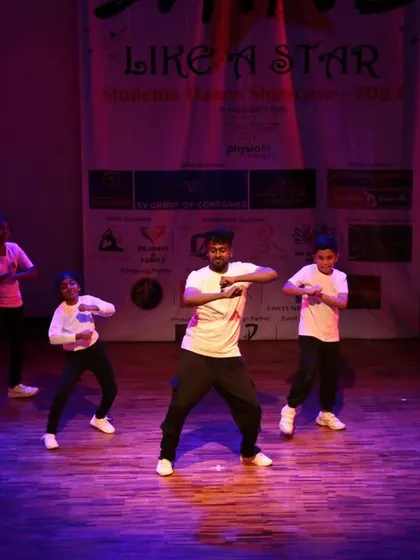 An instructor leading a class of young students on stage.