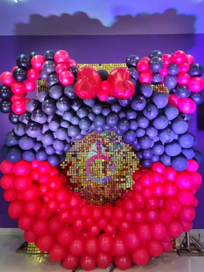 A fun Mickey Mouse-themed balloon decoration. We created a large Mickey head silhouette with a sequin backdrop, perfect for a photo booth.