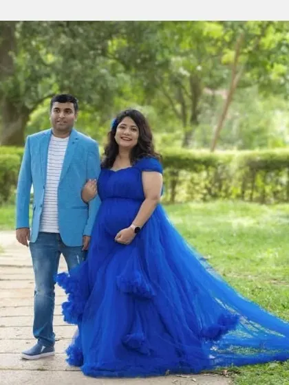 A lovely outdoor maternity shoot with the couple walking through a park. The royal blue ball gown with its long train adds a touch of fairytale magic.
