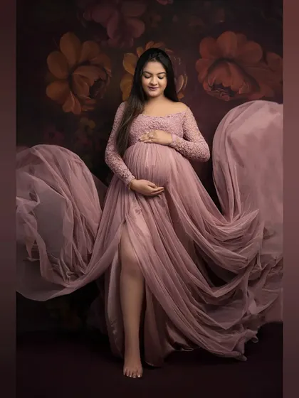 Lost in a dream. This full-length portrait captures the elegance of our dusty rose gown, with its delicate lace and flowing tulle creating a soft, romantic feel against a floral backdrop.