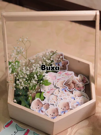 The beginnings of a teddy bear themed baby shower centerpiece, with custom cutouts and fresh baby's breath in a pinewood basket.