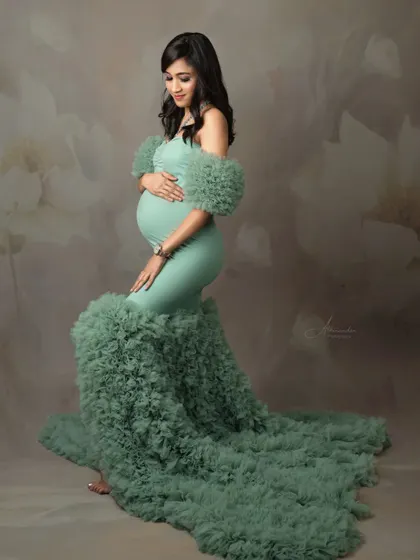 A beautiful solo portrait in the mint green ruffled gown. The floral-painted backdrop adds a soft, artistic touch to the photograph.
